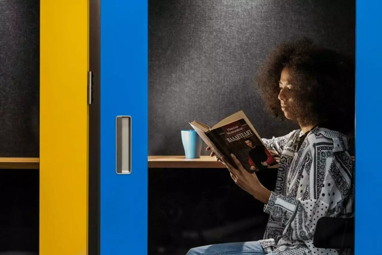 On y voit une cabine acoustique design avec une personne a l'intérieur